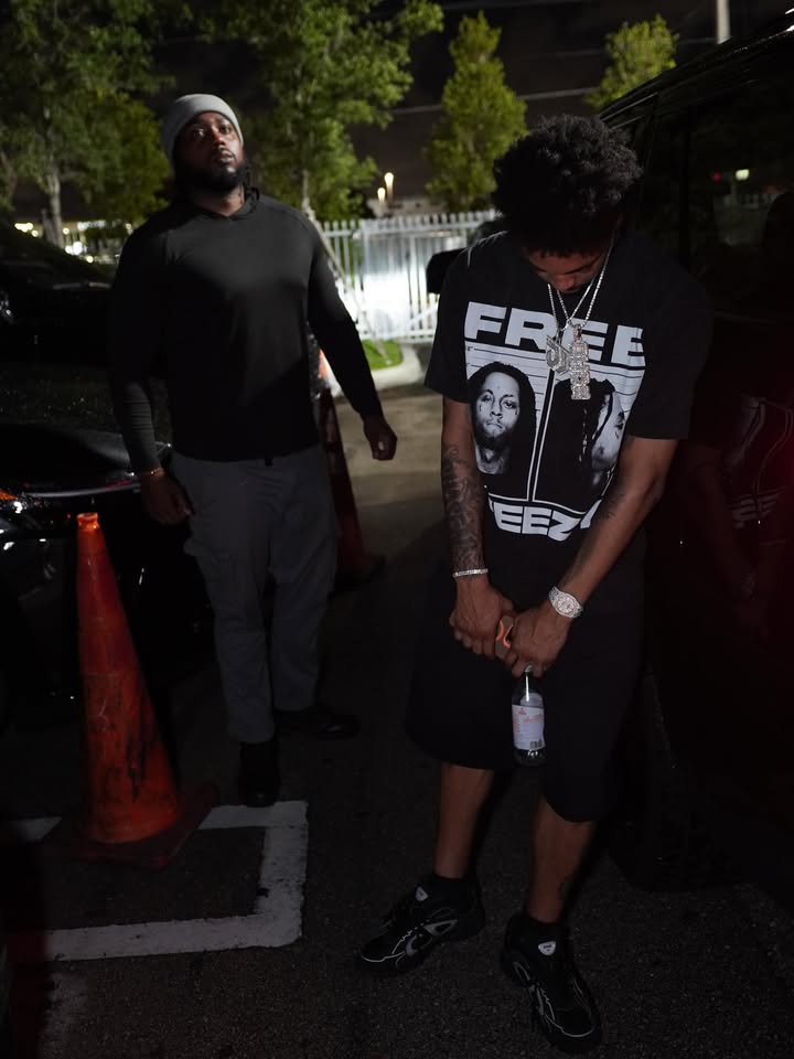 Dior Johnson in a black graphic tee and jewelry in a nightlife setting