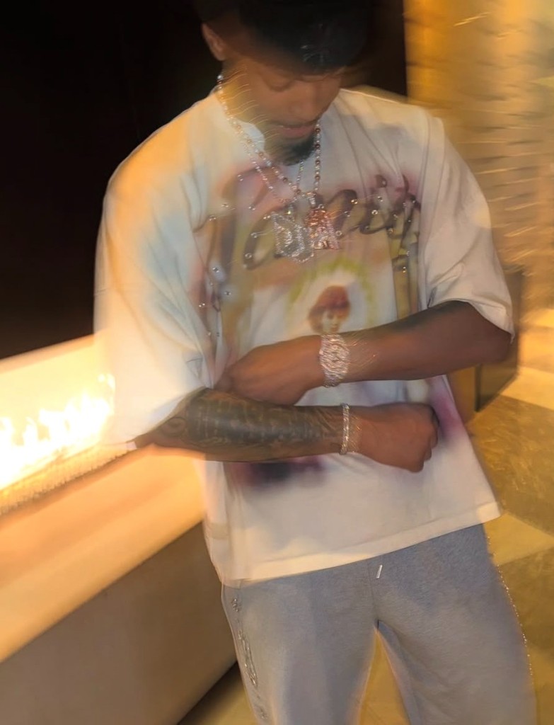 Dior Johnson wearing jewelry and a graphic shirt at night